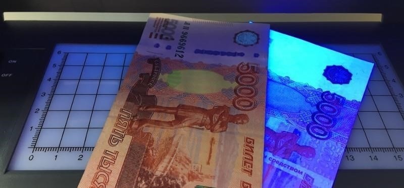 Проверка валюты с помощью ультрафиолетового излучения в магазинах